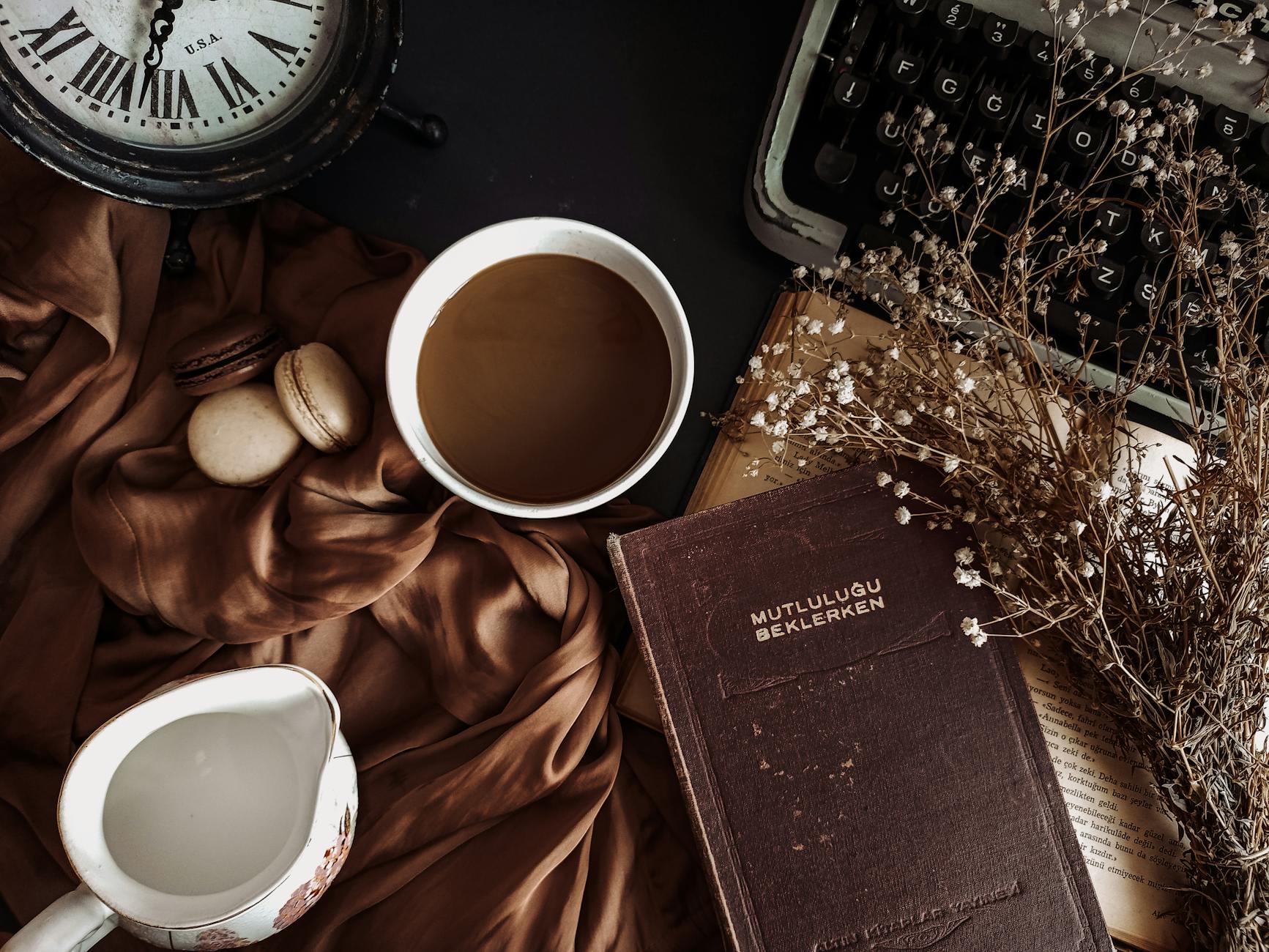 white ceramic mug beside brown satin textile