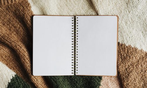 Blank opened notebook on a sweater