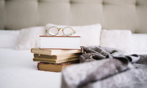 glasses-pile-books-bed
