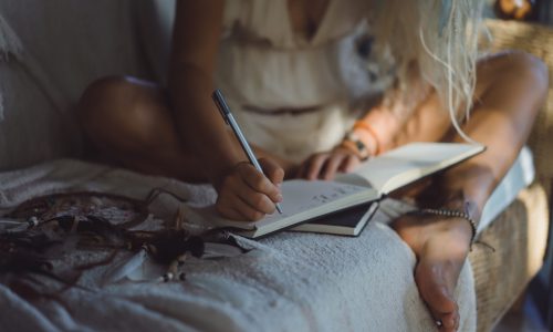 happy girl spends time at home in a cozy interior, writes 
and draws in a notebook.