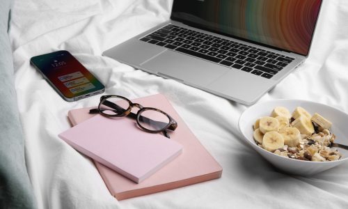 high-angle-smartphone-bed-with-laptop-glasses