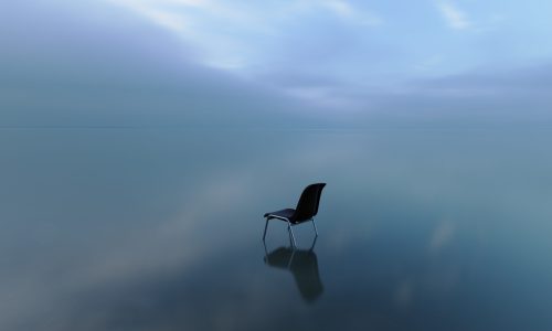 A single chair reflecting on a water surface on a stormy day