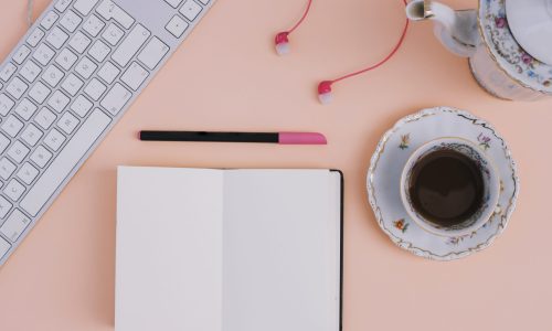 tea-earphones-near-notebook-keyboard