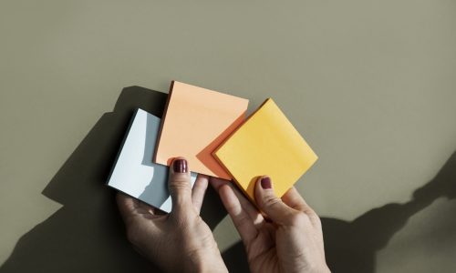 top-view-hands-holding-colorful-post-its