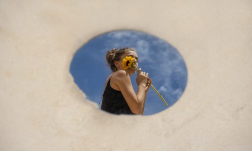 woman-posing-with-round-mirror-flower