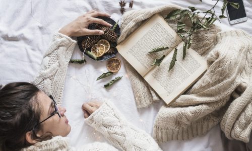 young-woman-lying-bed-with-book